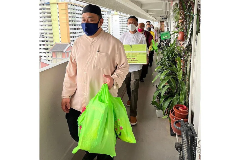 MERIAHKAN SUASANA: AP GRC Jalan Besar, Dr Wan Rizal Wan Zakariah (dua dari depan), berkunjung ke rumah warga emas untuk mengagihkan bubur dan kurma kepada mereka yang mempunyai masalah pergerakan di kawasan Geylang Bahru. - Foto FACEBOOK DR WAN RIZAL WAN ZAKARIAH