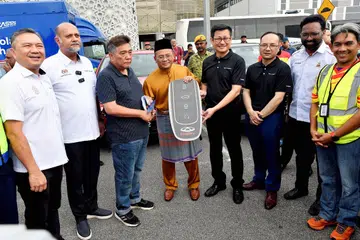 Menteri Besar Selangor, Datuk Seri Amirudin Shari (tengah), menyerahkan replika kunci kenderaan model, Chery, kepada seorang mangsa letupan dan kebakaran saluran paip gas bawah tanah, Encik Chen Ka Kim (tiga dari kiri), di Masjid Putra Heights, Subang Jaya, Selangor, pada 4 April. 