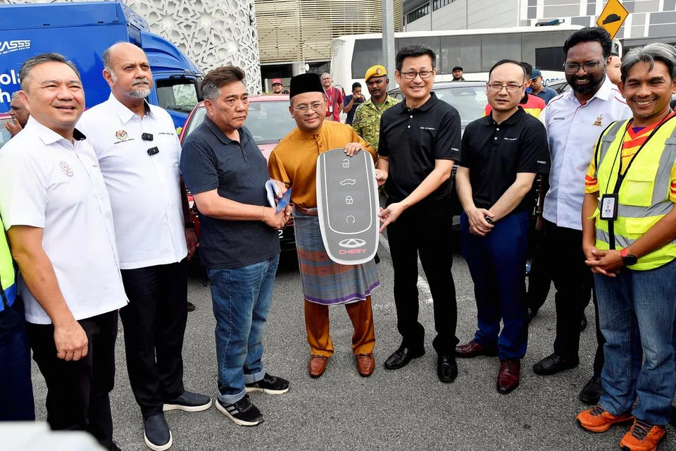 Menteri Besar Selangor, Datuk Seri Amirudin Shari (tengah), menyerahkan replika kunci kenderaan model, Chery, kepada seorang mangsa letupan dan kebakaran saluran paip gas bawah tanah, Encik Chen Ka Kim (tiga dari kiri), di Masjid Putra Heights, Subang Jaya, Selangor, pada 4 April. 