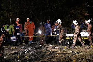 BAWA KELUAR MANGSA: Anggota Jabatan Bomba dan Penyelamat Malaysia (JBPM) dan unit Forensik membawa keluar mangsa yang terlibat dalam nahas pesawat terhempas di Bandar Elmina, Shah Alam.
