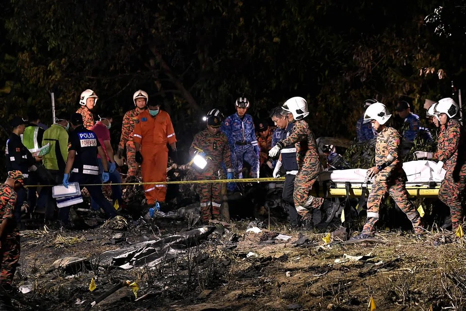 BAWA KELUAR MANGSA: Anggota Jabatan Bomba dan Penyelamat Malaysia (JBPM) dan unit Forensik membawa keluar mangsa yang terlibat dalam nahas pesawat terhempas di Bandar Elmina, Shah Alam.