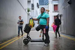 TABAH JALANKAN TUGAS: Bersyukur apabila ada pelanggan, yang melihat keadaan beliau apabila tiba di pintu rumah dengan bertongkat, memberinya tip, minuman dan kata-kata perangsang. - Foto BM oleh MARK CHEONG
