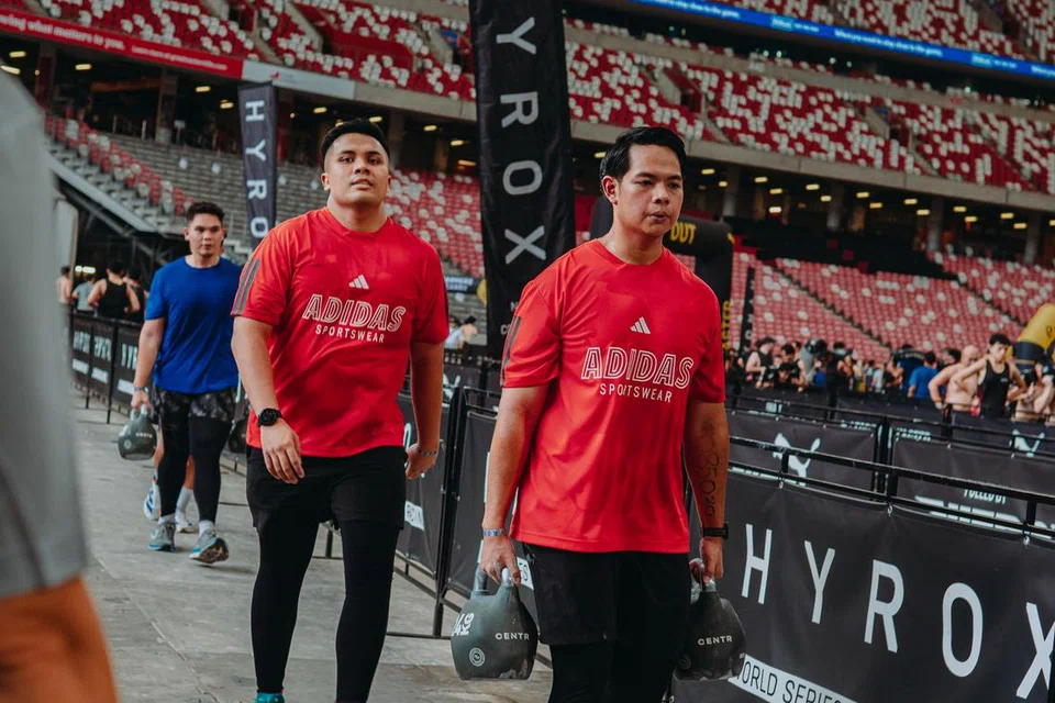 Encik Muhammad Huzaid Mohd Yazid bersama rakan kerjanya semasa salah satu kegiatan di peraduan Hyrox pada 29 Jun di Stadium Kebangsaan.