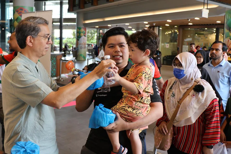 Menteri Negara (Ehwal Dalam Negeri merangkap Pembangunan Negara), Profesor Madya Dr Muhammad Faishal Ibrahim (kiri), turut serta mengagih bubur di Wisma Geylang Serai (WGS) pada 16 Mac. 