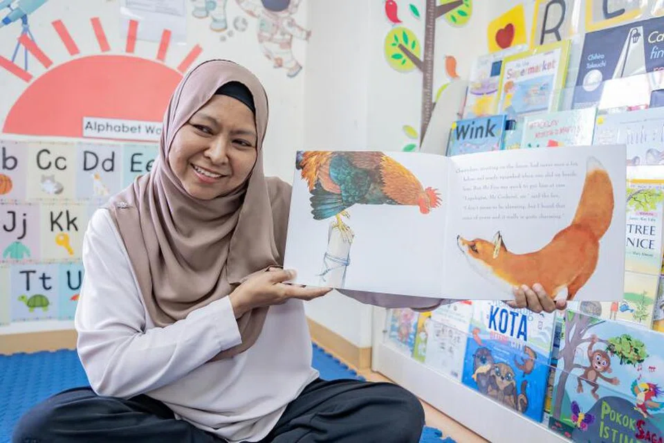 BACA BERSAMA: Cik Norhayati Mahat, 56 tahun, mengendali dua kelab kidsREAD di tadika PCF Sparkletots yang terletak di Clementi. 