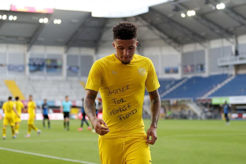 MAHUKAN KEADILAN: Pemain England Jadon Sancho memaparkan kemeja-T yang tertera ayat 'Keadilan untuk George Floyh' selepas menjariangkan gol bagi Dortmund dalam satu perlawanan Bundesliga kelmarin.