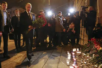 SUASANA HIBA: Presiden Russia, Encik Vladimir Putin, meletakkan jambangan bunga di luar stesen kereta api metro Tekhnologicheskiy Institut di St. Petersburg, Russia. - Foto REUTERS