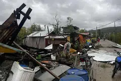 Foto edaran yang diambil pada 26 September 2025 dan diterima daripada laman Facebook Palang Merah Filipina (Cawangan Masbate) pada 28 September ini menunjukkan seorang penduduk memeriksa rumah yang musnah di sebuah kampung di bandar Masbate selepas Taufan Tropika Kuat Bualoi melanda wilayah tersebut