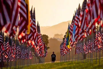 MEMPERINGATI: Seorang pengunjung berjalan sedang matahari terbenam di antara 'Gelombang Bendera' di Universiti Pepperdine di Malibu, California, bagi memperingati serangan 9/11. - Foto EPA-EFE 