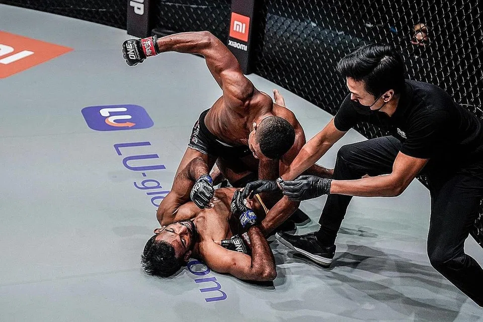 ACARA MMA: Pejuang MMA Singapura, Amir Khan (dengan pelekat merah pada sarung tangan) mencatatkan kemenangan atas Rahul Raju dari India di acara One Championship's Reign of Dynasties pada 9 Oktober lalu. - Foto ONE CHAMPIONSHIP