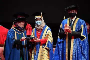 BAKTI BESAR DISANJUNG: Dr Oon Chiew Seng (kiri) menerima anugerah kehormat Doktor Persuratan NUS daripada Presiden Halimah Yacob dengan disaksikan Presiden NUS, Profesor Tan Eng Chye, di Pusat Kebudayaan Universiti semalam. - Foto BH oleh CHONG JUN LIANG
