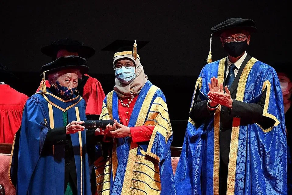 BAKTI BESAR DISANJUNG: Dr Oon Chiew Seng (kiri) menerima anugerah kehormat Doktor Persuratan NUS daripada Presiden Halimah Yacob dengan disaksikan Presiden NUS, Profesor Tan Eng Chye, di Pusat Kebudayaan Universiti semalam. - Foto BH oleh CHONG JUN LIANG