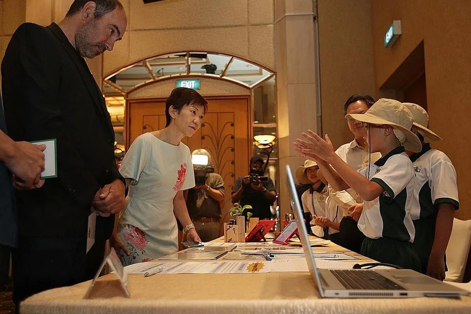 MASA DEPAN PERUBAHAN IKLIM: Cik Grace Fu, Menteri Kemampanan dan Sekitaran bersama duta, Encik Jonathan Eric Kaplan berinteraksi dengan pelajar dari Sekolah Rendah Xingnan, semasa lawatannya ke pameran di Forum Alam Sekitar 2022, semalam. - Foto BH oleh GIN TAY