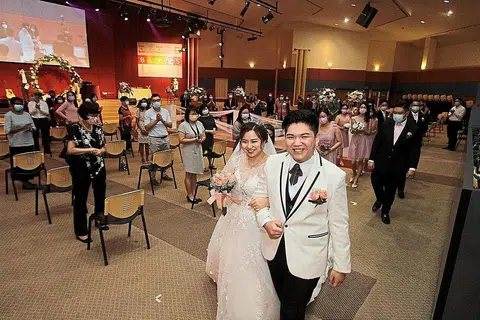 LEBIH CEPAT JADI PENGANTIN DISEBABKAN COVID-19: Cik Joy Ong dan suaminya, Encik Kelvin Looi, gembira majlis perkahwinan mereka berjalan dengan baik di Pusat Kristian Penang di George Town, walaupun terpaksa dicepatkan dua minggu. - Foto THE STAR