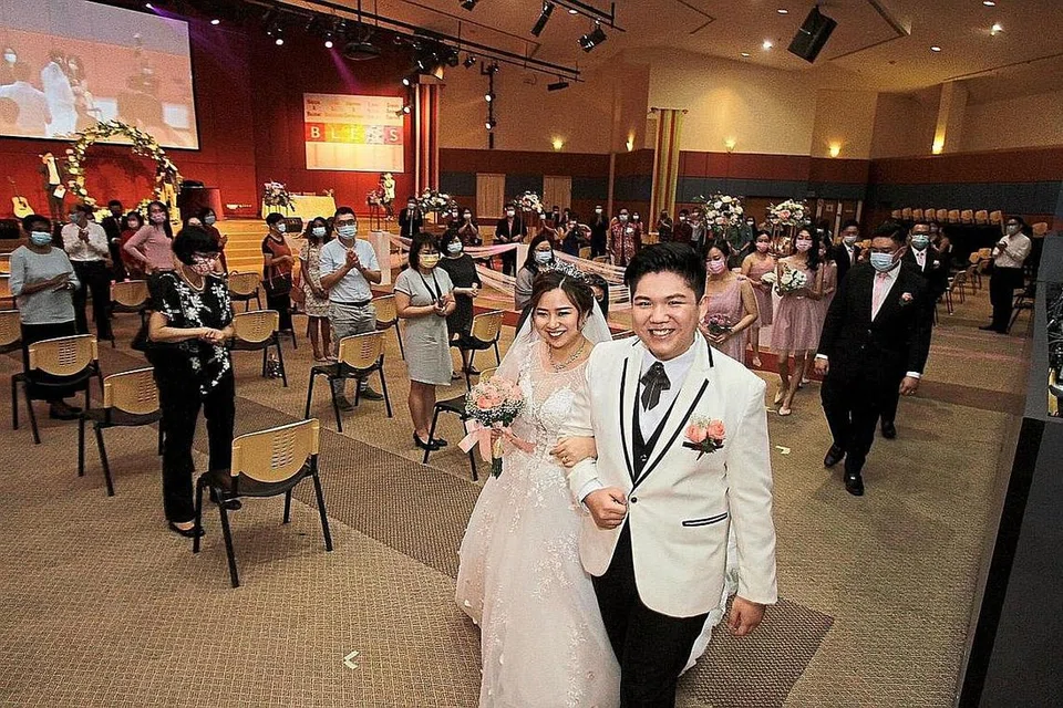 LEBIH CEPAT JADI PENGANTIN DISEBABKAN COVID-19: Cik Joy Ong dan suaminya, Encik Kelvin Looi, gembira majlis perkahwinan mereka berjalan dengan baik di Pusat Kristian Penang di George Town, walaupun terpaksa dicepatkan dua minggu. - Foto THE STAR