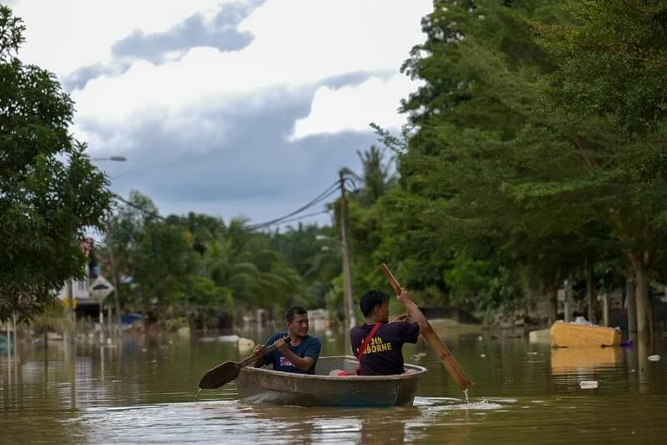 TERPAKSA MENDAYUNG SAMPAN: Penduduk di Mentakab, Pahang, terpaksa menaiki sampan bagi merentasi kawasan yang ditenggelami banjir. - Foto MOHD RASFAN/AFP 