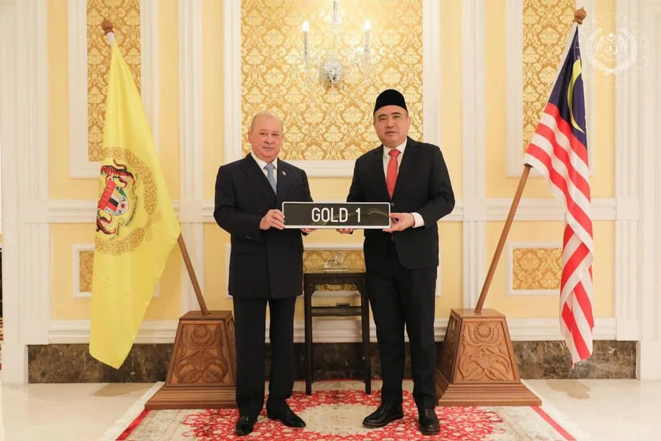 Yang di-Pertuan Agong Malaysia, Sultan Ibrahim (kiri), menerima simbolik plak nombor pendaftaran kenderaan ‘GOLD 1’ daripada Menteri Pengangkutan, Encik Anthony Loke, yang dibida pada harga RM1.5 juta, tertinggi dalam sejarah negara itu.