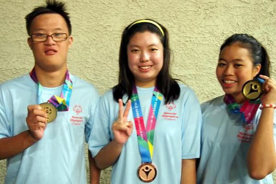 SEMUA PEMENANG: Danielle Moi (kanan) dan Bryan James Seow (kiri) memenangi pingat emas, sementara Nicole Fu meraih pingat gangsa semalam. - Foto SPECIAL OLYMPICS SINGAPORE