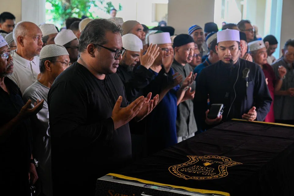 Anak sulung Allahyarham Mohamad Maidin Packer Mohd, Encik Mohamad Mahathir Mohamad Maidin (kiri), mengimamkan solat jenazah ayahnya di kediaman mereka di Tampines Street 33 pada 25 Jun.