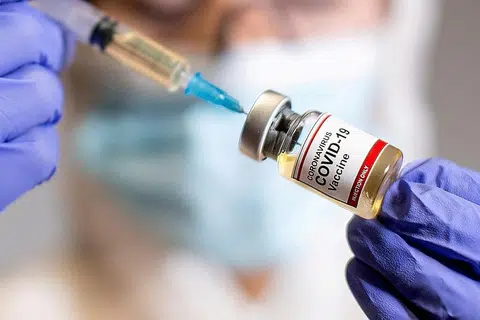 SEDIA PENAWAR: Seorang wanita berpelitiup memegang botol kecil dengan pelekat yang dinamakan 'Vaksin Koronavirus Covid-19 dan sebuah alat suntikan di sebuah makmal pada 30 Oktober lalu. - Foto REUTERS