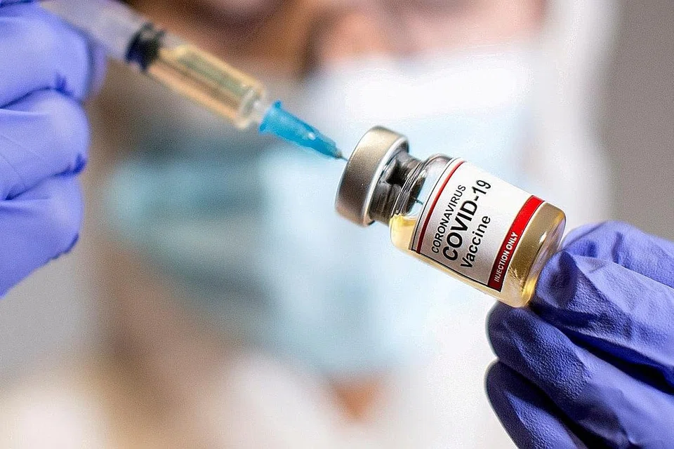 SEDIA PENAWAR: Seorang wanita berpelitiup memegang botol kecil dengan pelekat yang dinamakan 'Vaksin Koronavirus Covid-19 dan sebuah alat suntikan di sebuah makmal pada 30 Oktober lalu. - Foto REUTERS