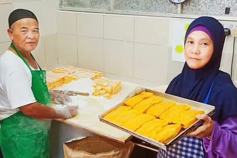KARIPAP 'BAI' RESIPI ASLI: Encik Ismail dibantu isterinya, Cik Hamidah, di gerai yang menjual khusus karipap 'bai' di Pusat Penjaja Circuit Road. - Foto BM oleh SAINI SALLEH.