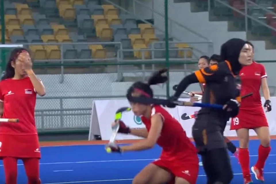 KAYU HOKI TERKENA KE MUKA: Pemain Malaysia kelihatan seperti telah menghayunkan kayu hokinya ke arah muka Syaheeza. Mujur Syaheeza tidak mengalami kecederaan dan lalu meneruskan perlawanan di mana Singapura tewas 5-0. - Foto SINGSOC