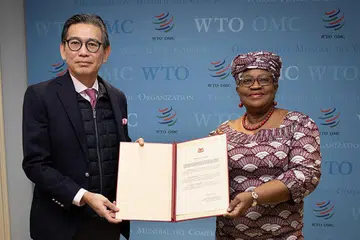 Duta Tan Hung Seng yang juga wakil tetap Singapura ke Pertubuhan Perdagangan Dunia (WTO) dan Pertubuhan Hak Cipta Intelektual Sedunia (kiri) menyerahkan penerimaan rasmi negara ini kepada Ketua Pengarah WTO, Cik Ngozi Okonjo-Iweala. - Foto WTO
