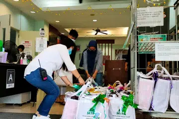 SEDIA DIAGIHKAN: Sukarelawan Persatuan Dana Amanah Muslimin (MTFA) bersiap sedia untuk proses pengagihan hadiah kepada kanak-kanak terjejas dan belia berisiko di luar Rumah Anak Yatim Darul Ihsan.  