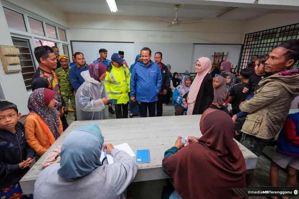 KONGSI NASIHAT: Menteri Besar Terengganu, Datuk Seri Dr Ahmad Samsuri Mokhtar (berbaju biru) menyantuni mangsa banjir ketika melawat pusat pemindahan sementara Sekolah Kebangsaan Chendering, Kuala Terengganu, Terengganu pada Selasa. 