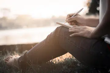 Individu sedang menulis surat (gambar hiasan). 