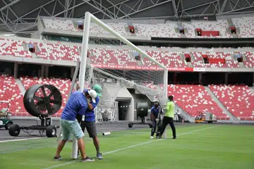 PERSIAPAN TERAKHIR: Beberapa pekerja sedang memasang gawang di Stadium Negara baru-baru ini, sebahagian persiapan menganjurkan Piala AFF Suzuki di sana. 
