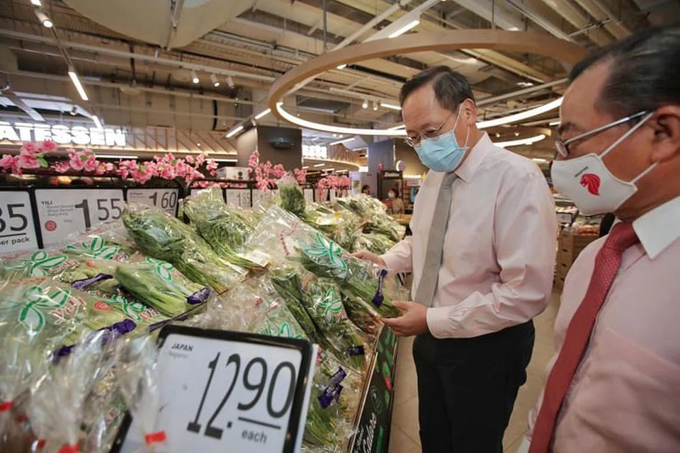 Menteri Kedua Perdagangan dan Perusahaan Encik Tan See Leng dan ketua pegawai eksekutif FairPrice Group, Encik Seah Kian Peng, (kanan) di pasar raya besar FairPrice Xtra di Parkway Parade pada Jumaat (22 Jan).