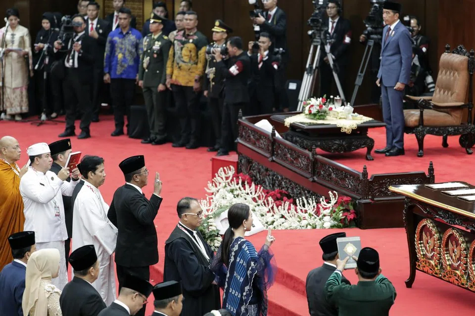 Presiden Joko ‘Jokowi’ Widodo (atas, kanan) menghadiri majlis perasmian Anggota Parlimen di bangunan Parlimen di Jakarta, Indonesia, pada 1 Oktober dengan 732 anggota Majlis Perwakilan Rakyat (MPR) mengangkat sumpah untuk berkhidmat dari 2024 hingga 2029.