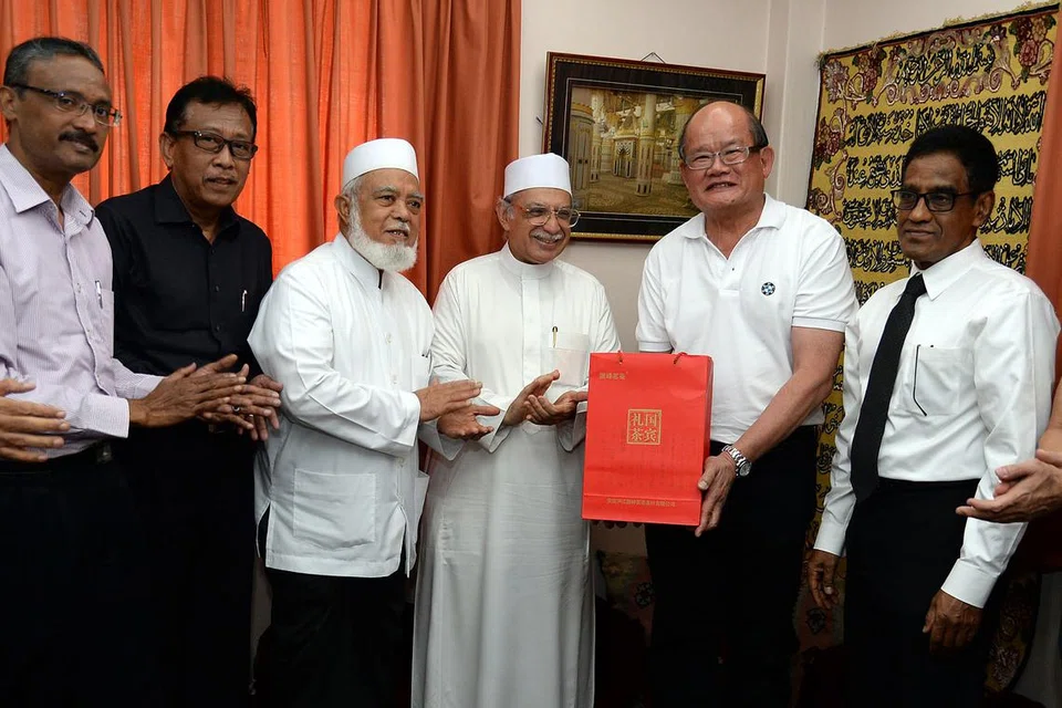 CENDERAMATA TANDA MUHIBAH: Habib Hassan Muhammad Al-Attas (berjubah putih) menghadiahkan cenderamata kepada Pemangku Presiden Buddhist Lodge, Encik Kuah Poh Beng. Bersama beliau ialah (dari kiri) Encik Shaick Fakrudeen S. Ali, Encik Paiman Supangat, mantan Mufti Syed Isa Semait dan Encik Noor Marican. - Foto IMAN ALIF RAHIM