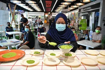 BELAJAR RESIPI BARU: Cik Munaliza bantu sediakan hidangan ikan kukus dengan bokchop dan sos hijau semasa acara demo memasak, Masak Masak semalam. - Foto BH oleh CHONG JUN LIANG