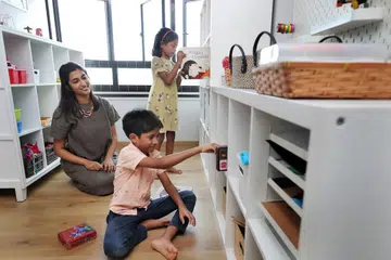 MEMBIASAKAN ANAK MENGEMAS: Cik Sundar memerhatikan anak-anaknya, Alisha and Aryan, mengemas bilik mainan mereka di rumah. - Foto BH oleh GAVIN FOO