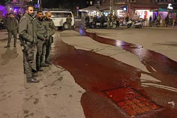 DESAK TEBUSAN DIBEBAS: Para pegawai keselamatan melihat cat merah sebagai simbol darah tebusan yang dituang di permukaan jalan raya oleh peserta protes dekat kediaman Perdana Menteri Israel di Baitulmakdis pada 22 Januari.