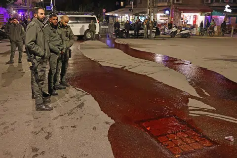 DESAK TEBUSAN DIBEBAS: Para pegawai keselamatan melihat cat merah sebagai simbol darah tebusan yang dituang di permukaan jalan raya oleh peserta protes dekat kediaman Perdana Menteri Israel di Baitulmakdis pada 22 Januari.
