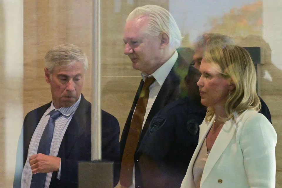 Pengasas WikiLeaks Julian Assange (tengah) dan peguamnya Cik Jennifer Robinson (kanan) berjalan melalui kawasan keselamatan sebaik tiba di Mahkamah Persekutuan Amerika Syarikat di  Kepulauan Mariana Utara di Saipan, pada 26 Jun 2024, 