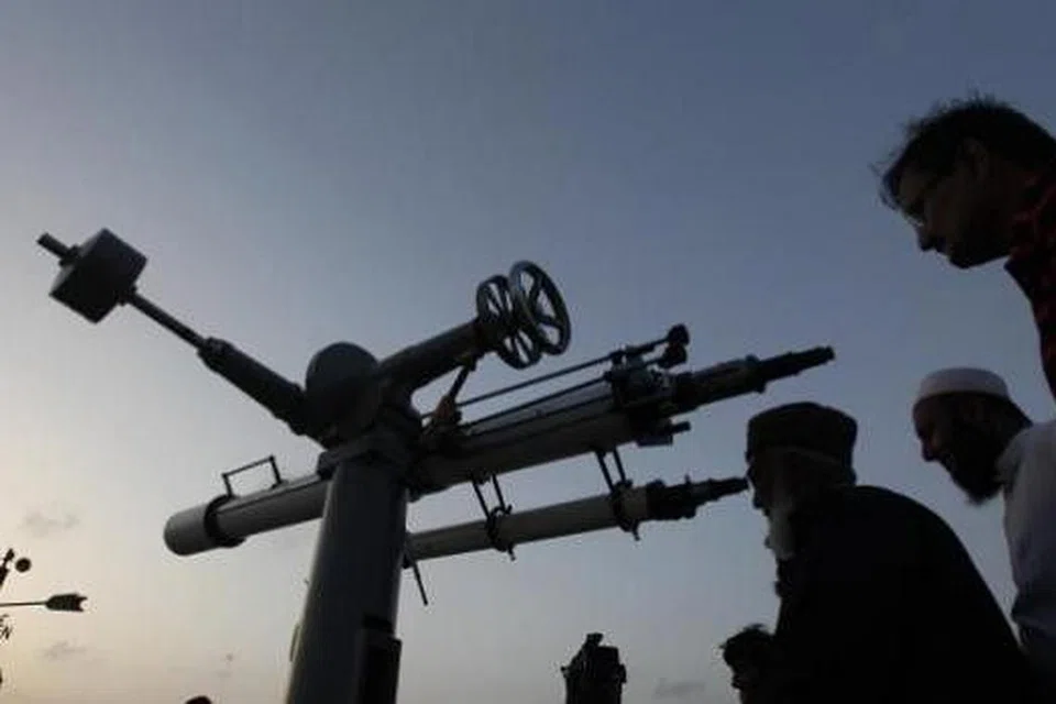 MENCARI ANAK BULAN: Jawatankuasa melihat anak bulan Pakistan menggunakan teleskop di Karachi (gambar atas) sementara Muslim di Cape Town, Afrika Selatan, menggunakan mata kasar untuk cuba melihat anak bulan Sabtu lepas bagi menandakan permulaan Ramadan di negara masing-masing. - Foto-foto AFP dan REUTERS.