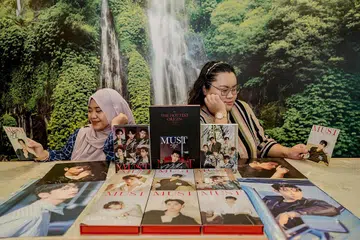 BUKAN SEKADAR 'FANGIRL' BIASA: Cik Suhana (kanan) dianggap sebagai 'fangirl' veteran yang akan memberikan panduan kepada peminat baru seperti Cik Putri (kiri) dalam memberikan sokongan kepada kumpulan kegemaran mereka. - Foto BM oleh NUR DIYANA TAHA