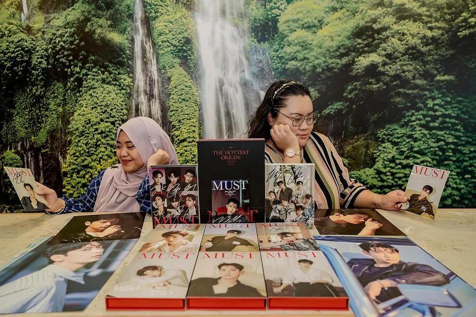 BUKAN SEKADAR 'FANGIRL' BIASA: Cik Suhana (kanan) dianggap sebagai 'fangirl' veteran yang akan memberikan panduan kepada peminat baru seperti Cik Putri (kiri) dalam memberikan sokongan kepada kumpulan kegemaran mereka. - Foto BM oleh NUR DIYANA TAHA