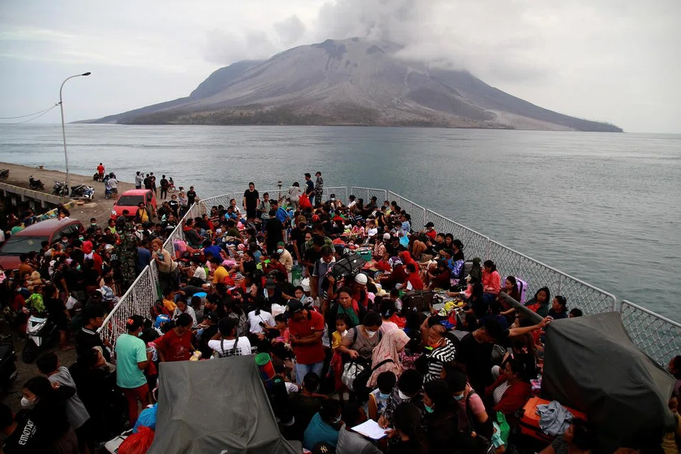 Sekitar 330 penduduk sedang dipindahkan dari Kabupaten Kepulauan Sitaro, Sulawesi Utara, di tengah-tengah letusan Gunung Ruang (latar belakang), meninggalkan Tagulandang pada 1 Mei 2024, ke Bitung dengan menaiki kapal KRI Kakap Angkatan Laut Indonesia. 