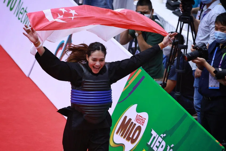 Nurul Suhaila Saiful meraikan kemenangan sambil mengibarkan bendera Singapura selepas menewaskan lawannya dari Malaysia dalam perlawanan akhir tanding wanita kategori 65-70kg di Gimnasium Bac Tu Liem pada 16 Mei 2022. Atlet pencak silat ini akhirnya meraih pingat emas di Sukan SEA Vietnam selepas tiga kali berturut-turut membawa pulang pingat gangsa.