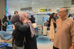 Ibu bapa Cik Saadiah Mohd Habib (kiri), dan Raja Muzaffar Raja Rosli (kanan) menyambut puteri mereka, Raja Nur Syakirah Raja Muzaffar Raja Rosli (tengah) di balai ketibaan Terminal 2, Lapangan Terbang Changi, pada 13 Mac.