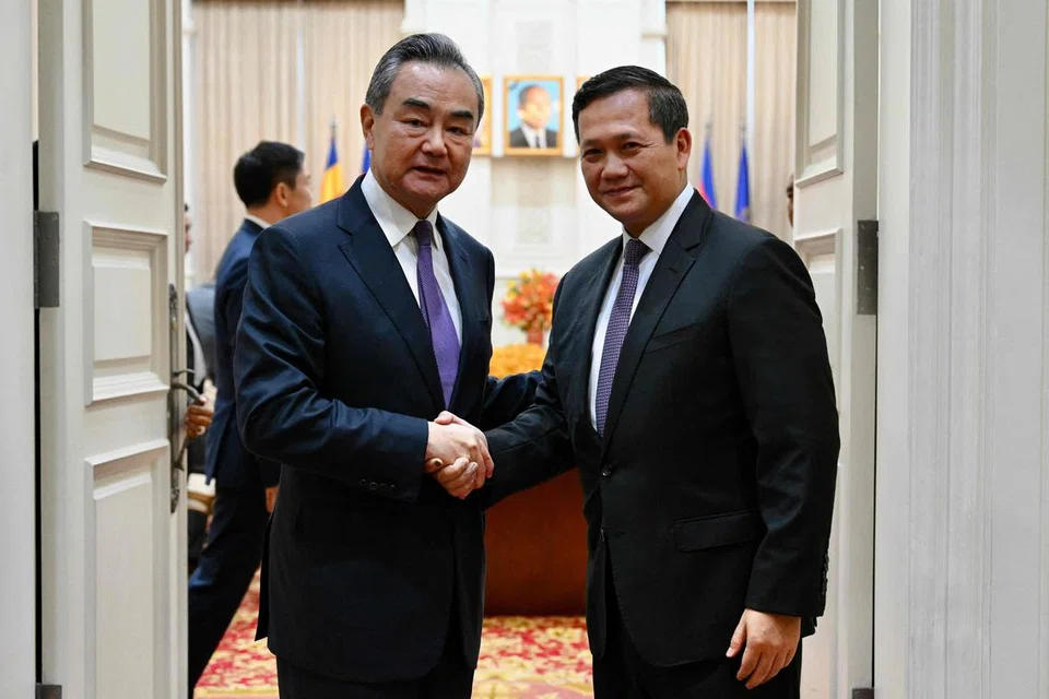 IKRAR ERAT HUBUNGAN: Foto ihsan Kabinet Kemboja ini menunjukkan bakal perdana menteri Kemboja, Encik Hun Manet (kanan) berjabat tangan dengan Menteri Luar China, Encik Wang Yi, dalam pertemuan mereka di Phnom Penh pada Ahad 13 Ogos. 
