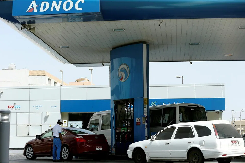 Seorang pekerja kelihatan mengisi minyak kereta di sebuah stesen minyak Adnoc di Abu Dhabi, Amiriah Arab Bersatu.