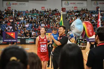Charmaine Soh (kiri), bersama suaminya, Ow Yong Chaan Loung, dan anak mereka, Cruz, menonton video penghormatan oleh rakan sepasukannya selepas beliau mengumumkan persaraannya daripada arena antarabangsa pada 28 Oktober. 