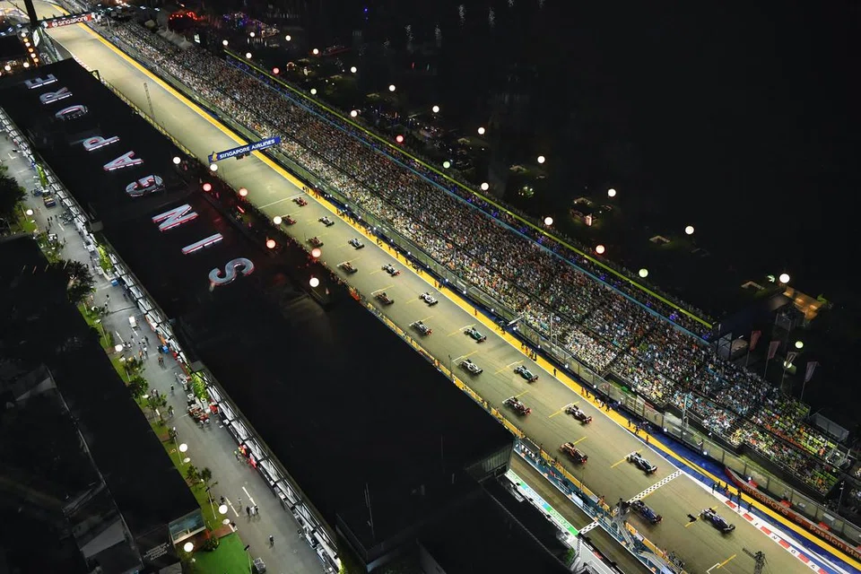 PAPARAN MENARIK: Kereta tersusun mengikut kedudukan grid sejurus sebelum final Grand Prix Singapura bermula pada 2 Oktober. Perlumbaan itu terpaksa ditangguh sekitar sejam kerana hujan. - Foto BH oleh CHONG JUN LIANG